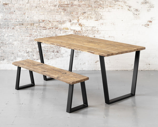 Rustic, reclaimed timber scaffold board dining table on matte black steel trapezoid base